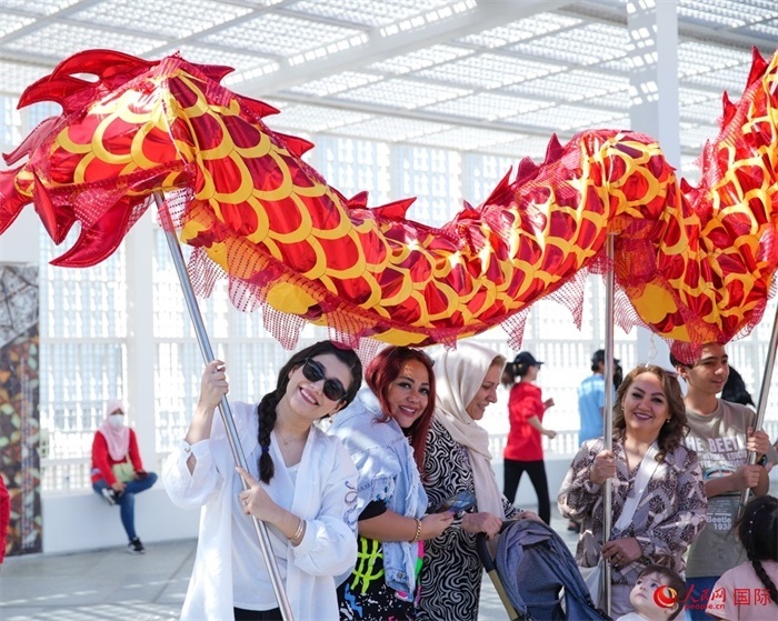 游客體驗(yàn)舞龍。 人民網(wǎng) 塔里克·易卜拉欣攝