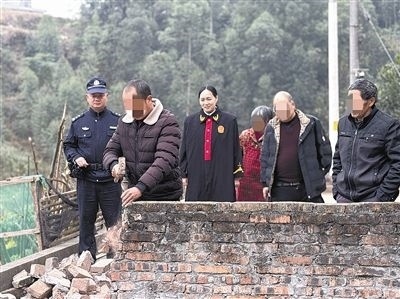  圖③：庭審結束后，在法官的見證下，陳某在院壩邊重新開鑿一條通道。