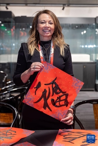 1月28日，在上海豫園舉行的民俗活動上，美國馬斯卡廷初中校長珍妮弗·李·弗里德利展示自己寫下的“?！弊帧?新華社記者 王翔 攝