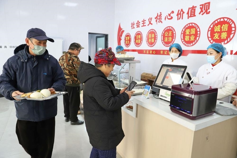 △2024年2月1日，市民在河北涿州市雙塔街道永濟(jì)秀園小區(qū)便民食堂內(nèi)購買午餐。