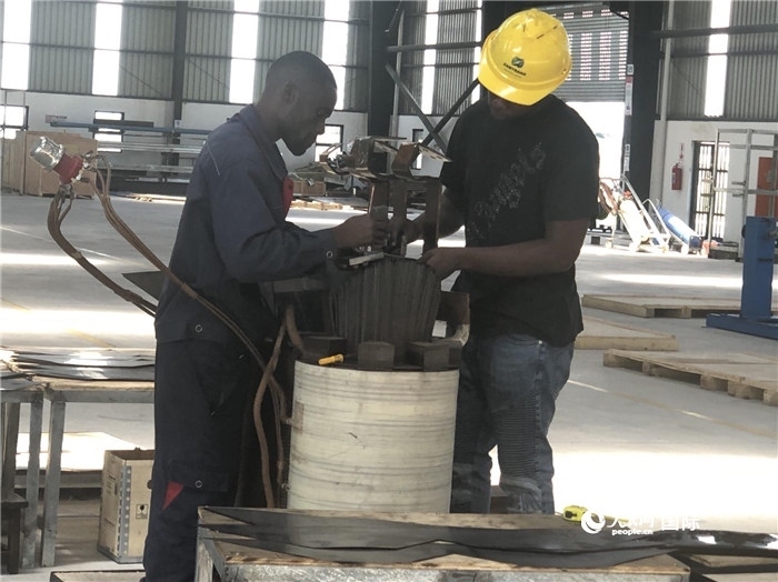 經(jīng)貿(mào)合作區(qū)廠房內(nèi)，當?shù)毓と苏诰o張作業(yè)。人民網(wǎng)記者 黃培昭攝