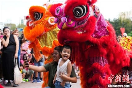 圖為舞獅表演吸引民眾合影。張興龍攝