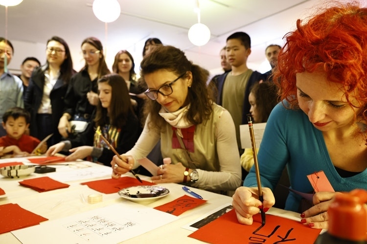 羅馬尼亞觀眾學(xué)習(xí)用毛筆寫“?！弊帧Ｖ袊幕行墓﹫D