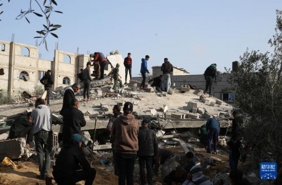  3月3日，在加沙地帶南部城市拉法，人們查看被以軍空襲破壞的建筑。新華社發(fā)（哈立德·奧馬爾攝）