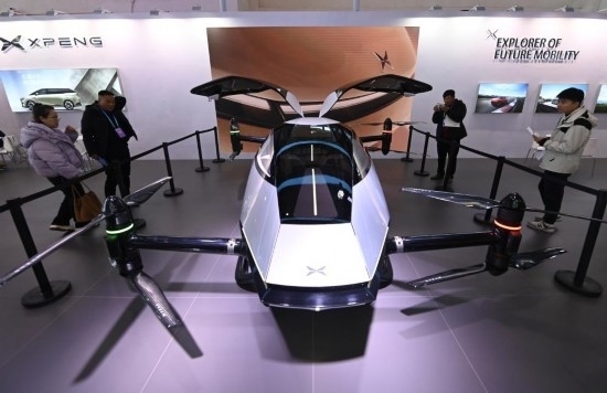 2023年12月1日，在鏈博會(huì)智能汽車鏈展區(qū)小鵬汽車展臺(tái)，參觀者觀看一臺(tái)智能飛行器。新華社記者蔡湘鑫攝