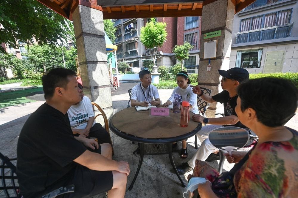 △2023年7月21日，在位于浙江杭州臨安區(qū)錦南街道水岸陽光小區(qū)的陽光議事廳，街道干部在聽取居民們反映的問題及意見。