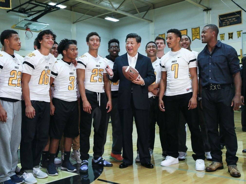 2015年9月23日，國家主席習(xí)近平參觀美國塔科馬市林肯中學(xué)。這是習(xí)近平在學(xué)校體育館，同上橄欖球訓(xùn)練課的學(xué)生們親切交談。新華社記者 蘭紅光 攝