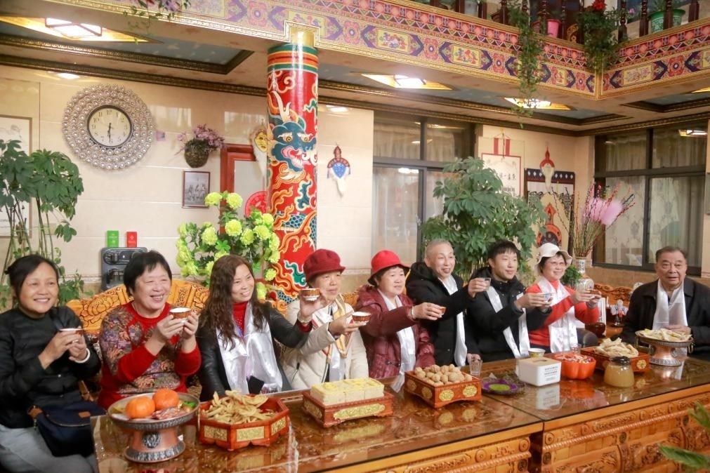 游客們?nèi)胱∶袼藓?，舉杯共飲酥油茶。新華社記者 邱星翔 攝