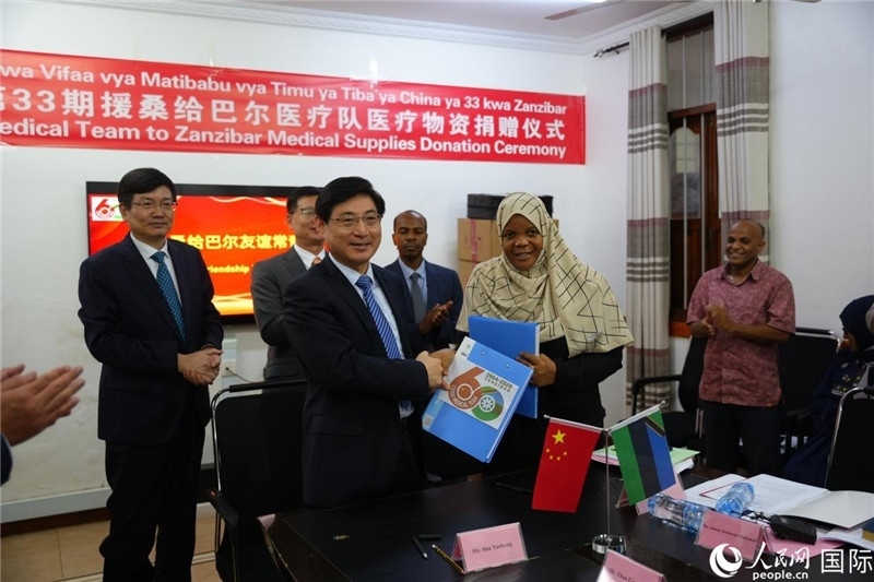 江蘇省蘇北人民醫(yī)院黨委書記束余聲與桑衛(wèi)生部首席秘書哈比巴交換捐贈書。中國援桑醫(yī)療隊(duì)供圖