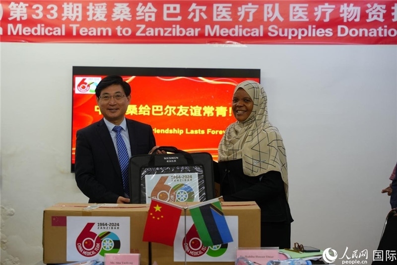 江蘇省蘇北人民醫(yī)院黨委書記束余聲捐贈物資與桑衛(wèi)生部首席秘書哈比巴。中國援桑醫(yī)療隊(duì)供圖