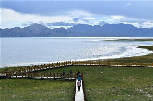 △ 游客行走在青?，敹嗫h冬格措納湖畔的木棧道上。