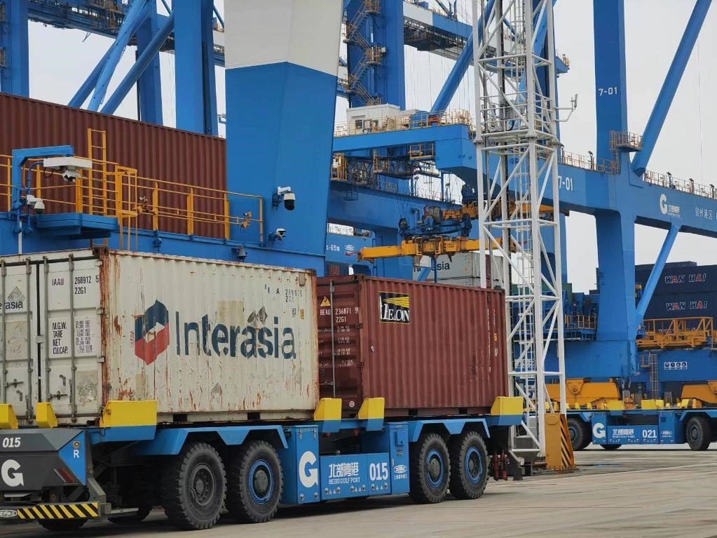 在欽州自動(dòng)化集裝箱碼頭，智能導(dǎo)引運(yùn)輸車在運(yùn)送集裝箱。新華社記者趙歡 攝