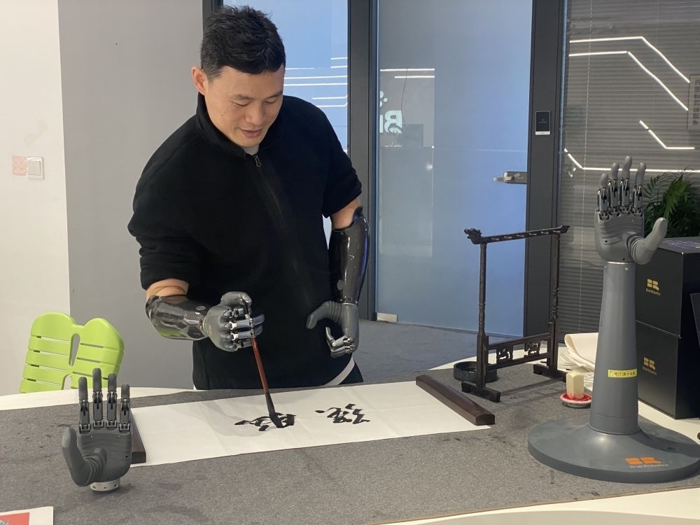 2024年3月29日，在浙江強(qiáng)腦科技有限公司展廳內(nèi)，失去雙手的產(chǎn)品體驗(yàn)官倪敏成依靠智能仿生手寫毛筆字。新華社記者 魏一駿 攝