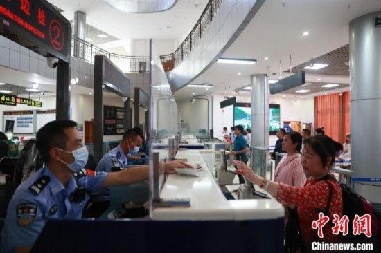 圖為旅客在磨憨口岸辦理通關(guān)手續(xù)。雷雨 攝