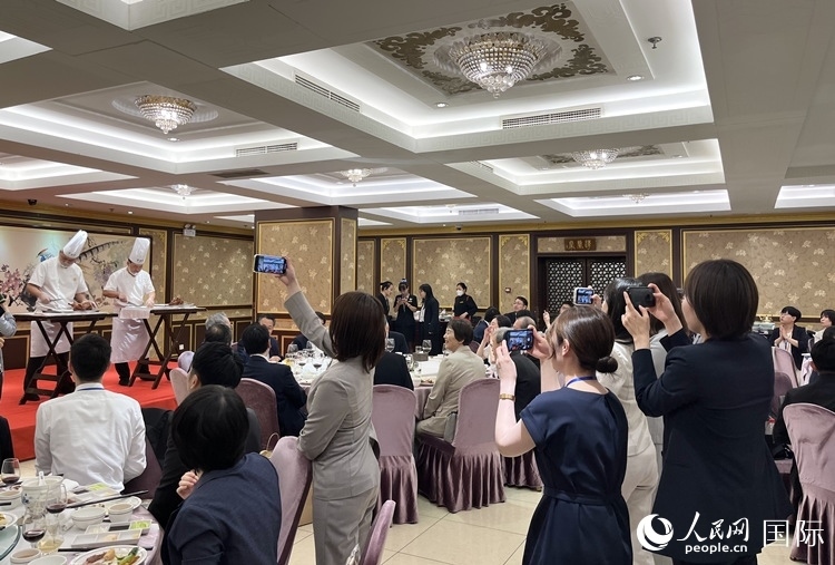 國家級非物質(zhì)文化遺產(chǎn)、全聚德片鴨工藝吸引代表團(tuán)成員拍照留念。