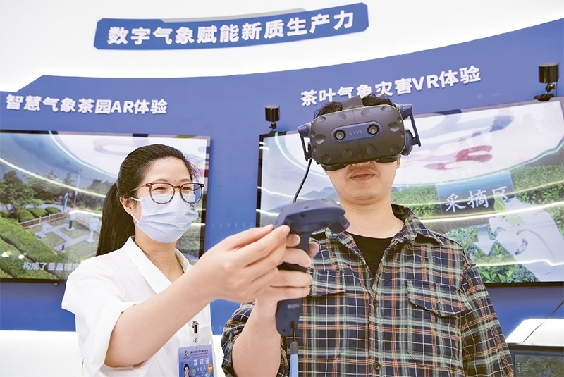 2024年5月23日，第七屆數(shù)字中國(guó)建設(shè)峰會(huì)現(xiàn)場(chǎng)體驗(yàn)區(qū)在福州海峽國(guó)際會(huì)展中心向?qū)I(yè)觀眾開(kāi)放。本次現(xiàn)場(chǎng)體驗(yàn)區(qū)圍繞本屆峰會(huì)主題“釋放數(shù)據(jù)要素價(jià)值，發(fā)展新質(zhì)生產(chǎn)力”，設(shè)置“數(shù)字惠民”、“數(shù)字能力”、“數(shù)字基礎(chǔ)”、“數(shù)字生態(tài)”、“數(shù)字賦能”五大板塊。圖為一名觀眾（右）在數(shù)字氣象賦能新質(zhì)生產(chǎn)力展臺(tái)上進(jìn)行體驗(yàn)。 新華社記者 魏培全/攝