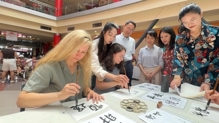 羅馬尼亞友人在活動現(xiàn)場學(xué)寫漢字。中國駐羅馬尼亞大使館領(lǐng)僑處供圖