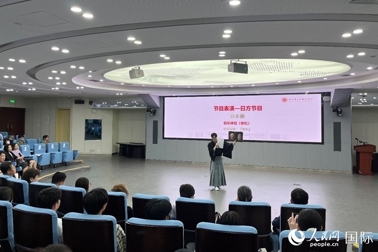 日本大學(xué)生介紹能樂知識(shí)。人民網(wǎng)記者 陳思攝