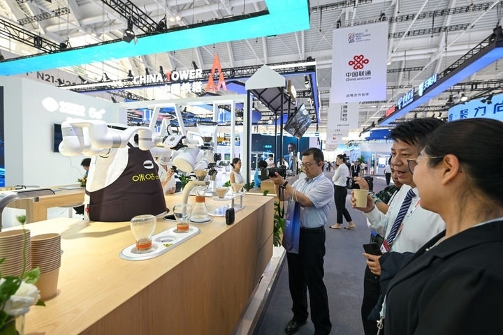 6月20日，與會者品嘗機器人沖調(diào)出的咖啡。新華社記者 孫凡越 攝