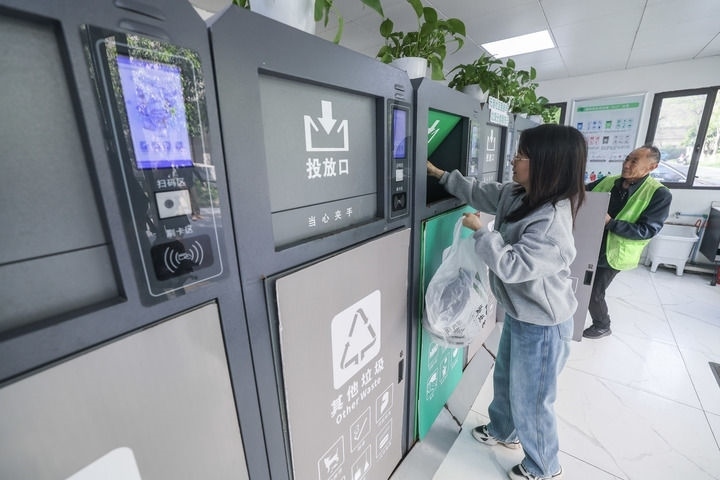 2024年4月10日，在浙江省湖州市吳興區(qū)飛英街道新華府小區(qū)內(nèi)，居民在垃圾分類智能系統(tǒng)的指導(dǎo)下進(jìn)行垃圾分類投放，居民的投放情況將實(shí)時(shí)匯總到智慧服務(wù)平臺，會有相應(yīng)的積分獎勵。新華社記者 徐昱 攝