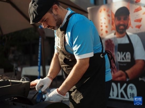 7月19日，在蕪湖古城，馬丁在當(dāng)天舉行的啤酒節(jié)上制作牛排。新華社發(fā)（繆雨晨 攝）