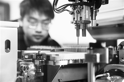 四川某公司，工人正進行微型鉆頭研磨鉆尖工序操作。