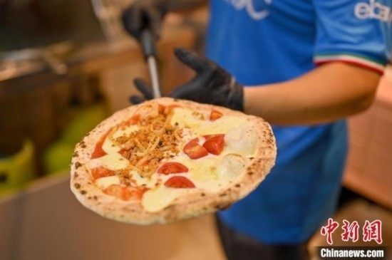 近日，韋榮耀展示他制作的“老友味”披薩。 俞靖 攝