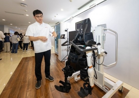 2024年5月24日，在位于上海市嘉定區(qū)的上海交通大學(xué)醫(yī)學(xué)院附屬瑞金醫(yī)院腫瘤質(zhì)子中心，工作人員介紹由瑞金醫(yī)院醫(yī)生和醫(yī)療公司共同研發(fā)的用于恢復(fù)患者下肢的醫(yī)療機(jī)器人。新華社記者 王翔 攝