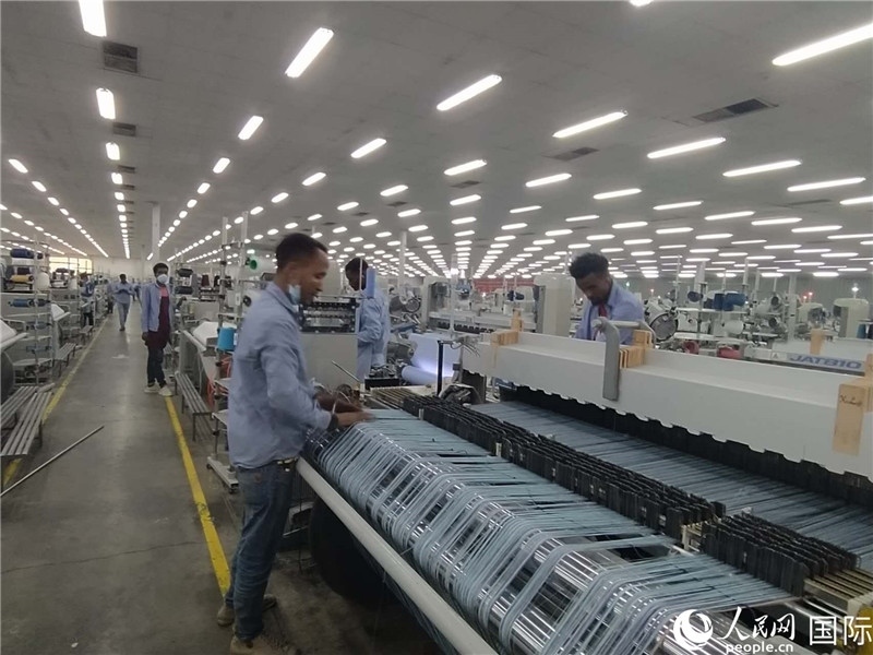 無錫金茂埃塞面料廠車間內(nèi)，當(dāng)?shù)毓と苏谝唤z不茍地作業(yè)。人民網(wǎng)記者 黃培昭攝