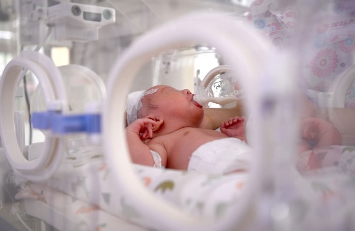 2024年6月1日，在西安國際醫(yī)學中心醫(yī)院新生兒科病房，護士為新生兒喂奶。 新華社記者 劉瀟 攝