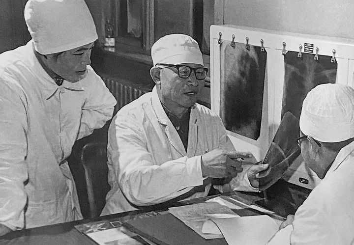 1980年1月16日，中日友好醫(yī)院首任院長辛育齡（中）在內(nèi)蒙古結(jié)核病院與胸外科醫(yī)師討論病例（翻拍照片）。 新華社發(fā)