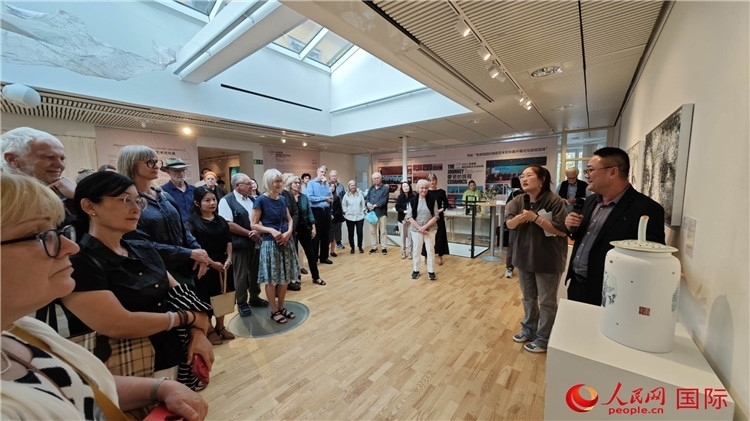 參展人、景德鎮(zhèn)陶瓷大學(xué)美術(shù)學(xué)院副院長(zhǎng)邵長(zhǎng)宗（右一）向來(lái)賓介紹參展作品。人民網(wǎng)記者 殷淼攝