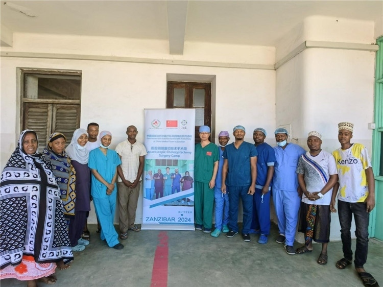 隊(duì)長蔣國慶（右七）和手術(shù)醫(yī)生、部分患者合影。中國援桑醫(yī)療隊(duì)供圖