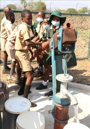 △2021年11月，在津巴布韋南馬塔貝萊蘭省省會關達的塞農(nóng)多小學，學生從中國援建水井里打水。