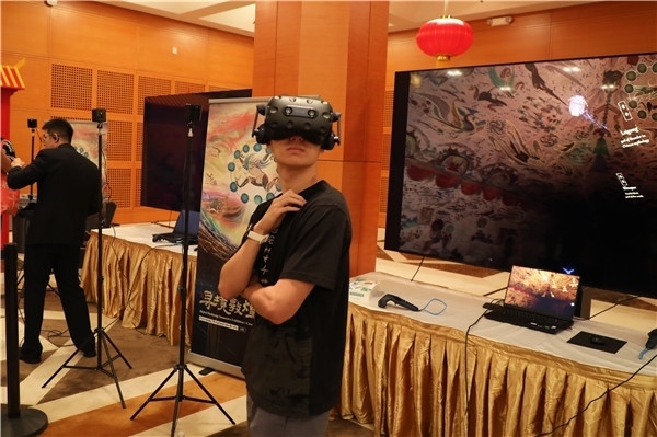 1、在本次活動的展覽現(xiàn)場，敦煌研究院與騰訊展示了“數(shù)字藏經(jīng)洞”和“尋境敦煌”等創(chuàng)新互動產(chǎn)品。圖為當(dāng)?shù)孛癖娡ㄟ^VR虛擬游覽洞窟。 人民網(wǎng)記者 李志偉攝