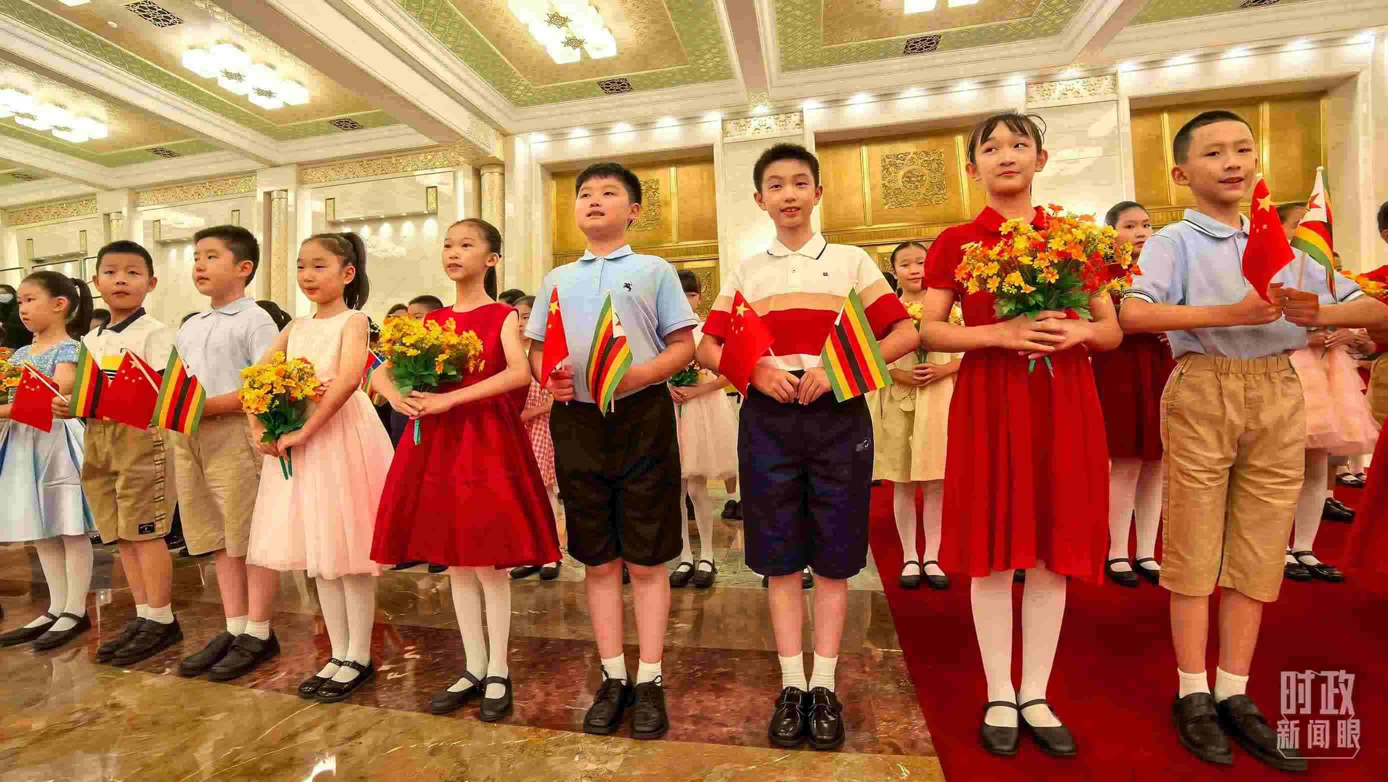 △現(xiàn)場歡迎津巴布韋總統(tǒng)訪華的青少年。（總臺央視記者鐘銳拍攝）