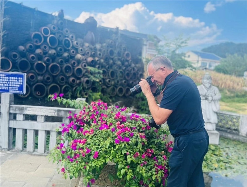 遠(yuǎn)處黔北民居錯(cuò)落有致，近處一只黑色的蝴蝶穿梭于粉紫色三角梅花叢間隙，與俄羅斯“大歐亞”總編輯弗拉基米爾·別列日內(nèi)赫的鏡頭玩起了捉迷藏，“你追我逃，不亦樂(lè)乎”。（張亞欣攝）