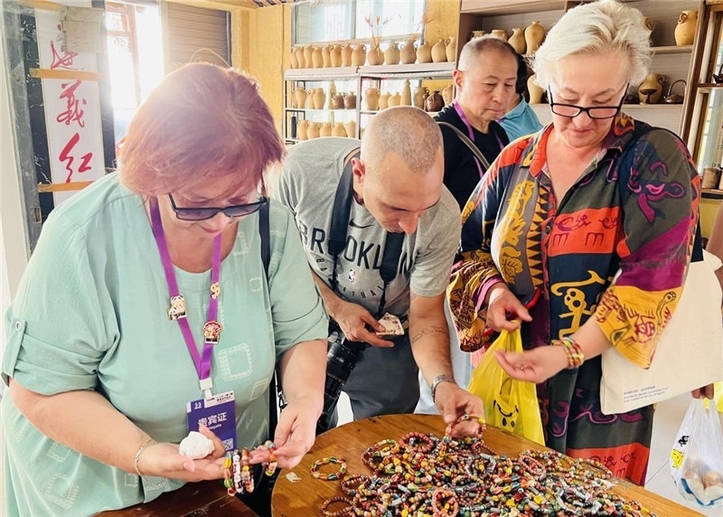 歐亞媒體考察團(tuán)成員在母氏陶藝館內(nèi)挑花了眼，色彩絢麗、質(zhì)地均勻的陶藝手串讓他們愛(ài)不釋手?！斑@里的東西都太實(shí)惠了！”塔吉克斯坦《索格特真理報(bào)》政論部主任娜塔利婭·多羅費(fèi)耶娃說(shuō)?；宓奶厣a(chǎn)品物美價(jià)廉，讓考察團(tuán)成員為家人好友買(mǎi)到了心儀的禮物，也為此次以四川成都為起點(diǎn)，路經(jīng)南充、廣安至貴州遵義的考察行程畫(huà)上了圓滿句號(hào)。（張亞欣攝）