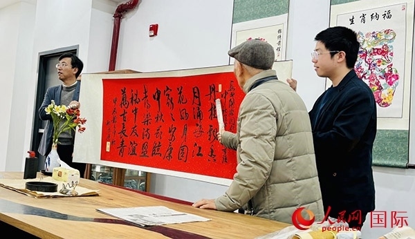 旅秘書法家向現(xiàn)場(chǎng)觀眾展示書法作品。人民網(wǎng)記者 宋亦然攝