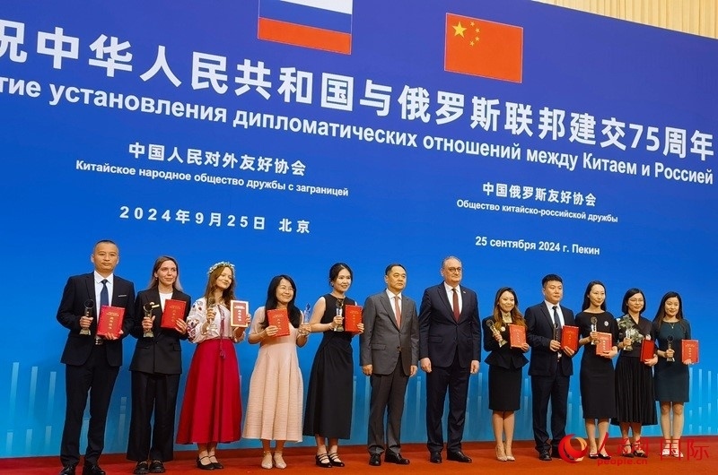 楊萬(wàn)明會(huì)長(zhǎng)和莫爾古洛夫大使為10位中俄青年友好微視頻創(chuàng)意大賽獲獎(jiǎng)代表頒獎(jiǎng)。人民網(wǎng)記者 李明琪攝