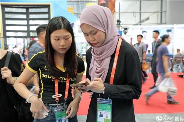 東博會現(xiàn)場，馬來西亞展商在同中方工作人員交談。人民網(wǎng)記者 趙益普攝