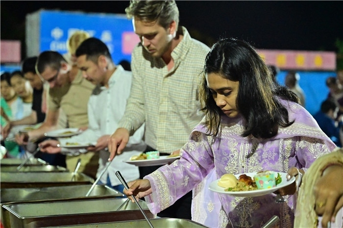 外國(guó)友人品嘗中國(guó)美食。馬騫攝
