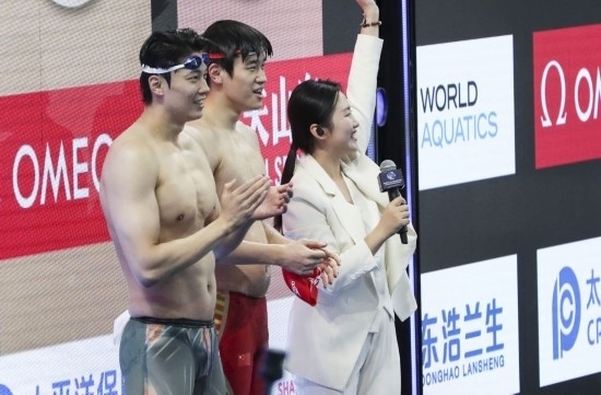  10月18日，汪順（左）和潘展樂在男子100米混合泳決賽后。新華社記者 方喆 攝