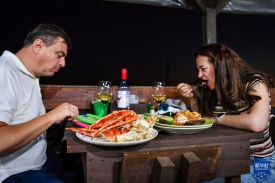 9月2日，食客們?cè)诙砹_斯符拉迪沃斯托克的一家餐館品嘗帝王蟹。新華社記者 曹陽(yáng) 攝