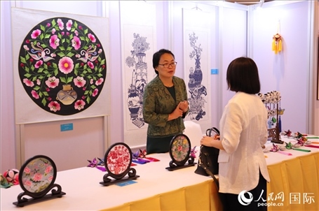 青海非遺文化傳承人向嘉賓介紹展品。人民網(wǎng)實習生姚欣可攝