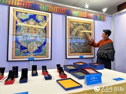 熱貢藝術(shù)國家級代表性傳承人夏吾角向嘉賓介紹作品。人民網(wǎng)記者 簡承淵攝