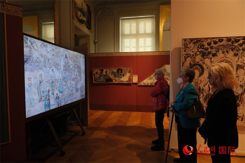 觀眾在展臺(tái)觀看錄像講解。人民網(wǎng)記者 尚凱元攝