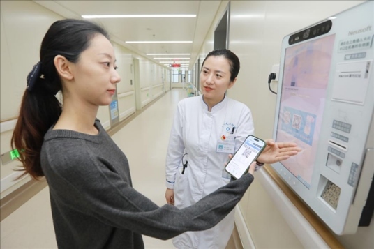 醫(yī)護(hù)人員引導(dǎo)患者在自助機(jī)前辦理自助入院手續(xù)。圖片來(lái)源：山東第一醫(yī)科大學(xué)第二附屬醫(yī)院