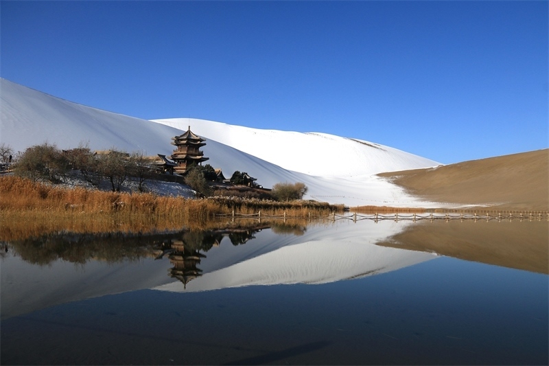 鳴沙山月牙泉景區(qū)雪景。敦煌市委宣傳部供圖，張曉亮攝