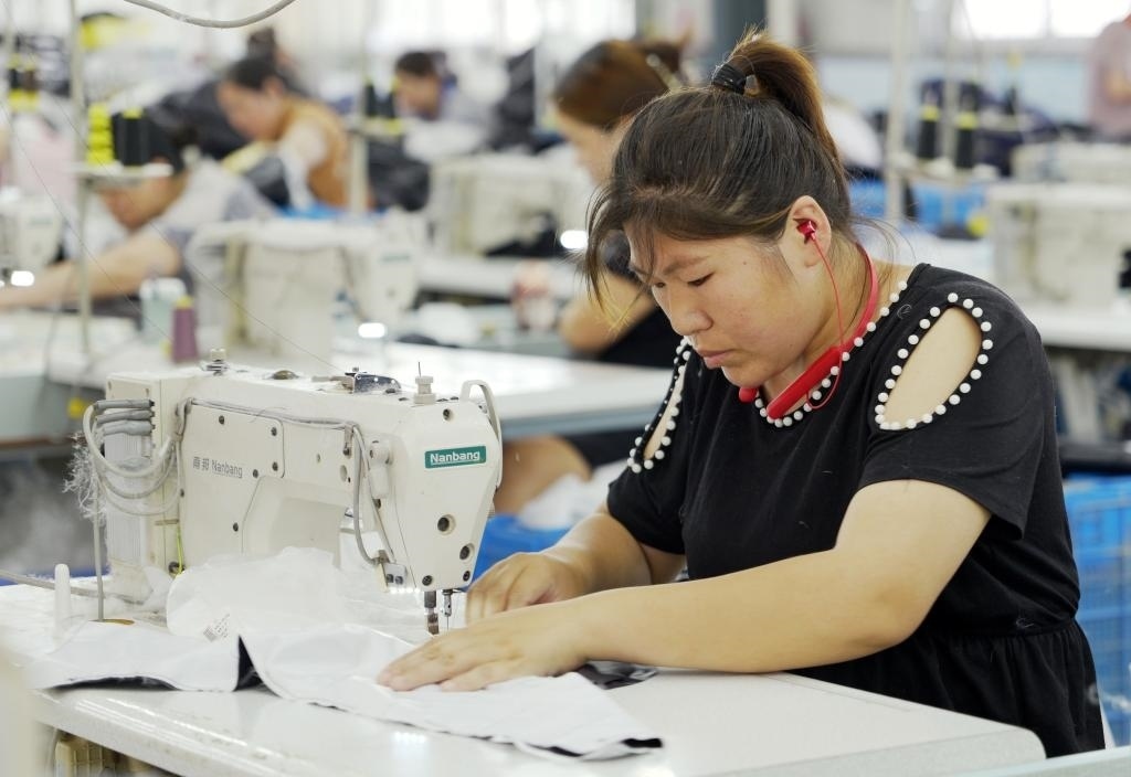 5月20日，村民在李寨村服裝加工廠內(nèi)忙碌。河南省周口市沈丘縣馮營(yíng)鎮(zhèn)李寨村地處豫東平原。近年來(lái)，乘著脫貧攻堅(jiān)與鄉(xiāng)村振興政策的東風(fēng)，李寨村積極探索產(chǎn)業(yè)發(fā)展模式，通過(guò)“龍頭企業(yè)+村集體經(jīng)濟(jì)+農(nóng)戶”的方式，逐漸發(fā)展形成肉牛養(yǎng)殖、設(shè)施農(nóng)業(yè)、服裝加工、康養(yǎng)民宿等產(chǎn)業(yè)，以產(chǎn)業(yè)振興助力鄉(xiāng)村振興。新華社記者 李嘉南 攝